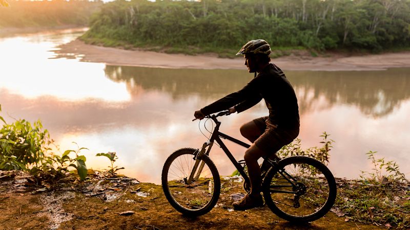 Mountain biking Peru Amazon rainforest and river bank