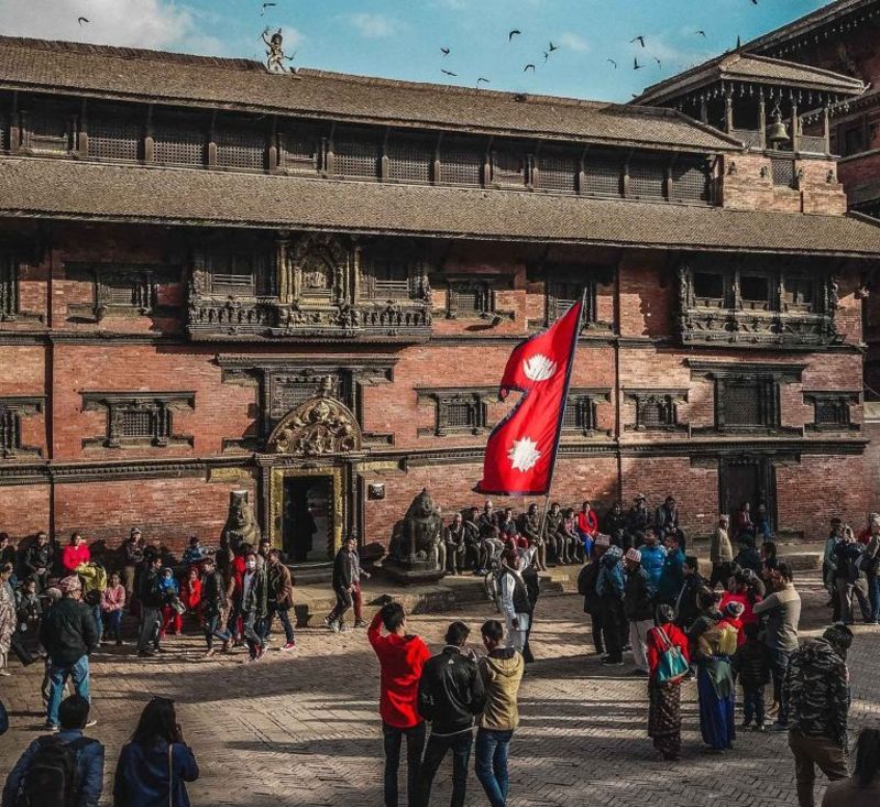 Nepal-flag-in-kathmandu-historic-building-and-crowd