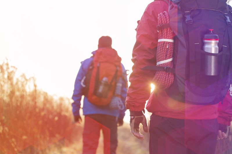 Two male hikers wearing backpacks as seen from behind