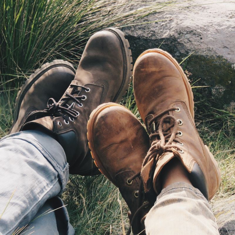Hikers wearing hiking boots and sitting on the grass