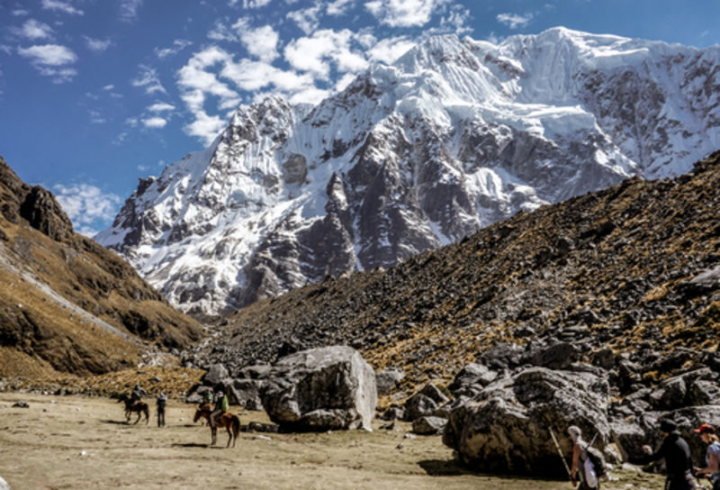 Men on horses approaching path to Salkantay Mountain Pass