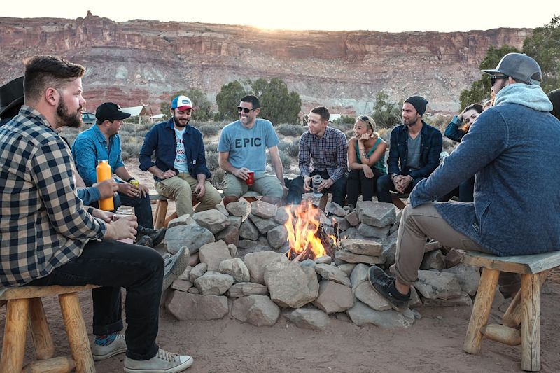 Group of young people sitting around a campfire