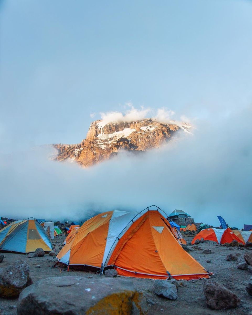 Beste. Barranco campsite tents among the clouds with Uhuru Peak showing through, Kilimanjaro