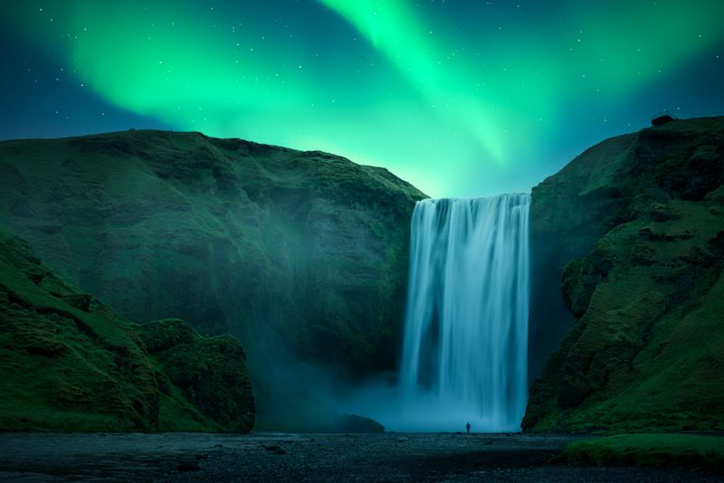 Aurora Borealis over famous Skogafoss waterfall on Skoga river, Iceland