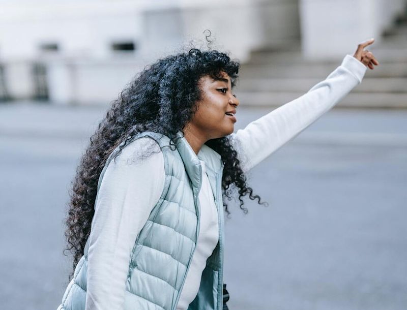 Woman in warm clothes haling a taxi 