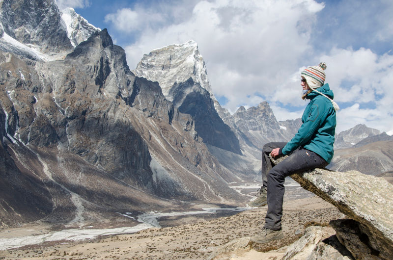Woman trekker on Everest Trek enjoying the view above Dingboche