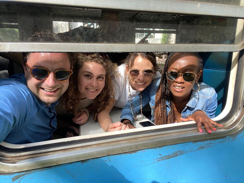 Friends sitting together and smiling through train window