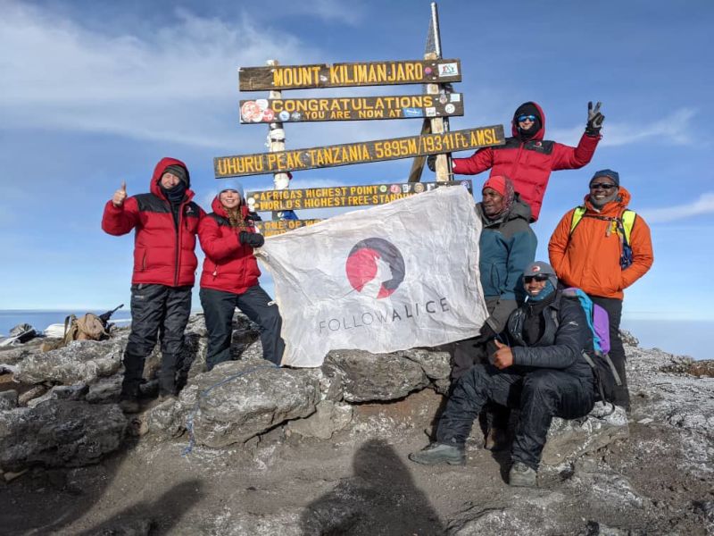 Follow Alice group pic Uhuru Peak, Kilimanjaro, red jackets, Jan 2023