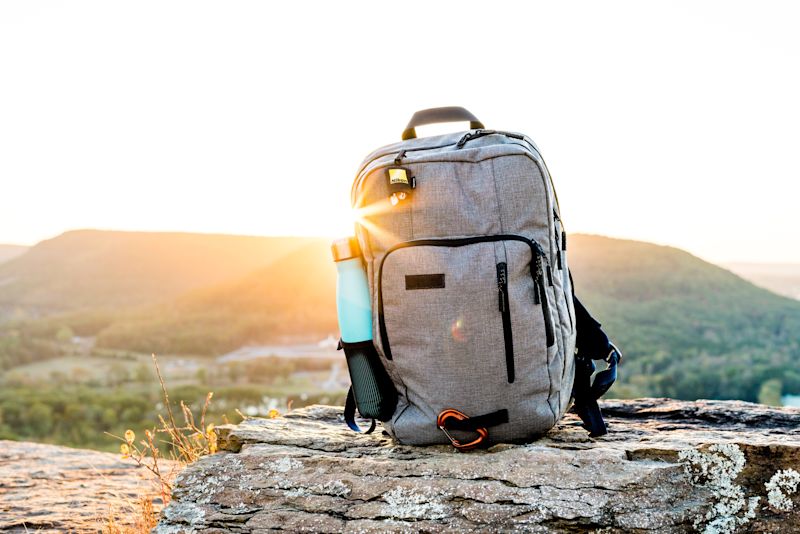 Grey backpack with blue water bottles in side pocket