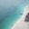 Aerial view of Kendwa Beach, with lots of thatched beach umbrellas, Zanzibar, Tanzania