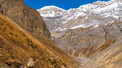 Trekker walking on footpath in the himalayas on the Annapurna Circuit Trek