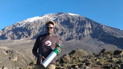 Chris on mountain with oxygen cylinder