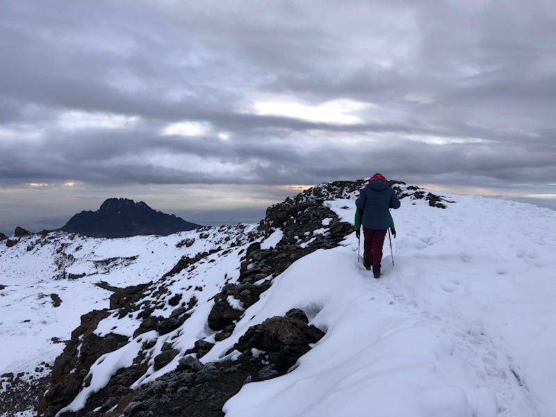 Trekker hiking through snow on Kilimanjaro
