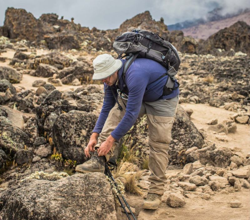 Tying trekking boots on Kilimanjaro hike