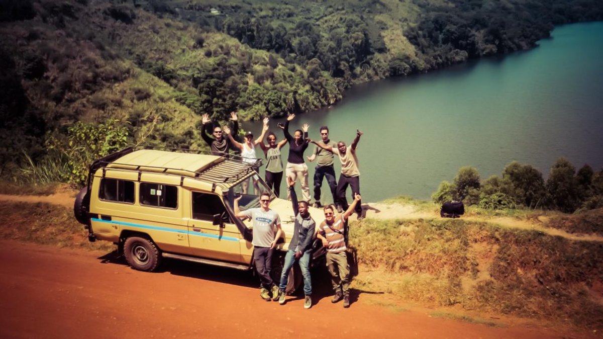 Friends on safari by vehicle and lake