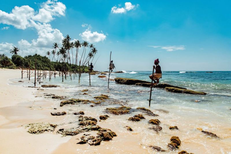 Stilt fisherman on beach in Sri Lanka
