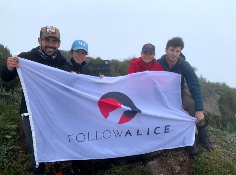 Follow Alice flag held by hikers crouching down, best time to visit Uganda