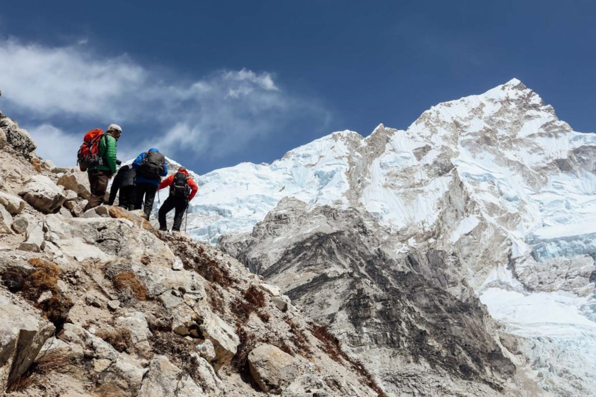 Trekkers climbing a mountain using trekking poles 