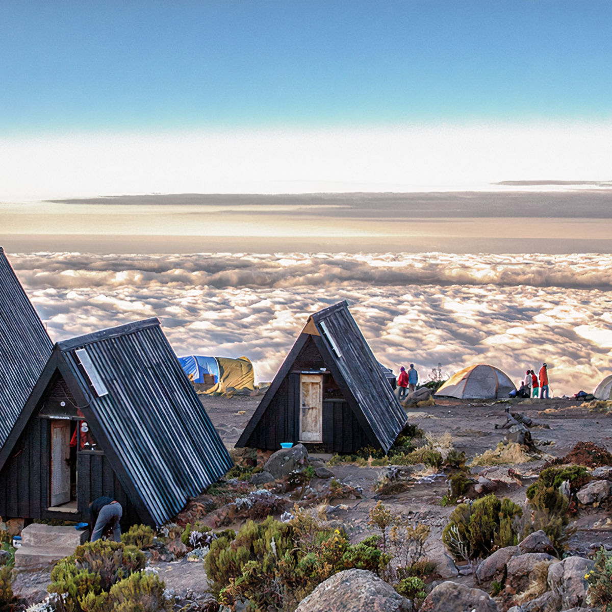A-frame huts at MArangu route campsite with blanket of cloud below