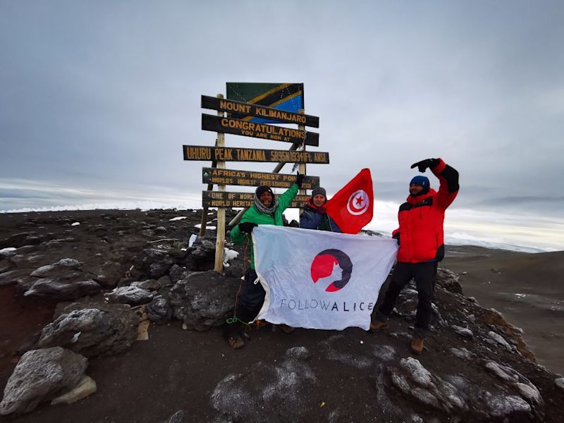 Trekkers with flags at the summit of Mt Kilimanjaro, Tanzania safety