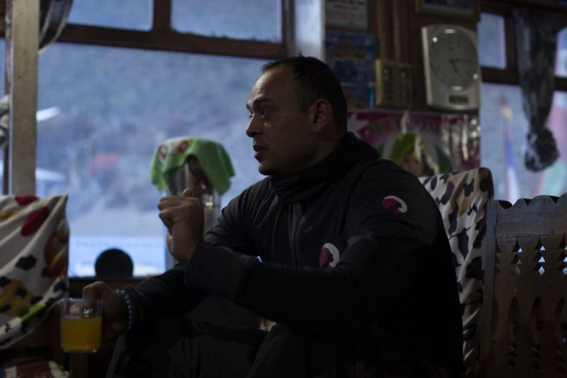 Man in Follow Alice top in teahouse in Annapurna