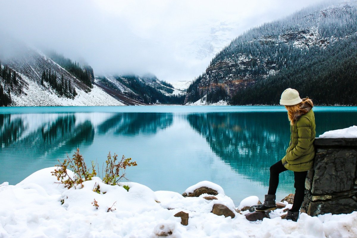 Woman in snowy landscape by lake