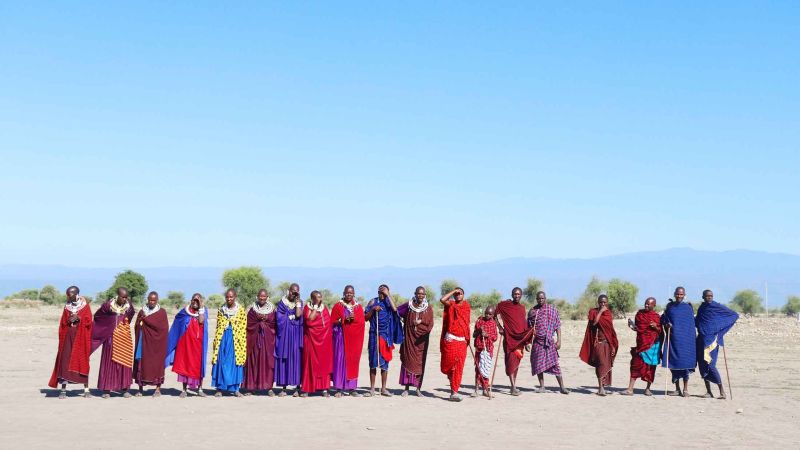 Maasai tribe standing in a line on the sand