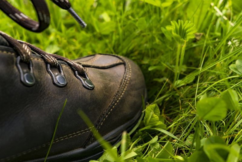 Close up of a leather hiking boot in the grass