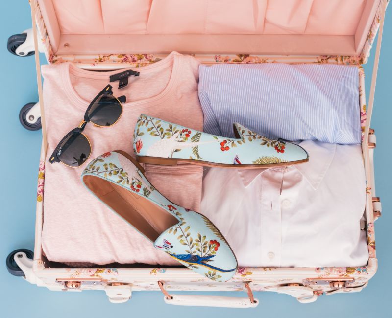 pink suitcase with clothes and shoes travel