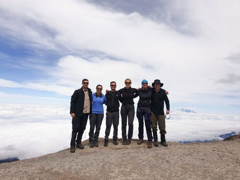 Smiling group photo on Kilimanjaro with clouds behind