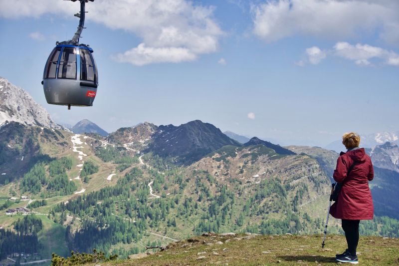 Woman hiker in Alps with cable car overhead