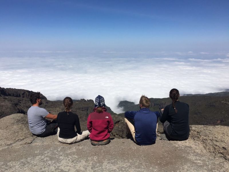 Group of friends looking out at the clouds on Kilimanjaro