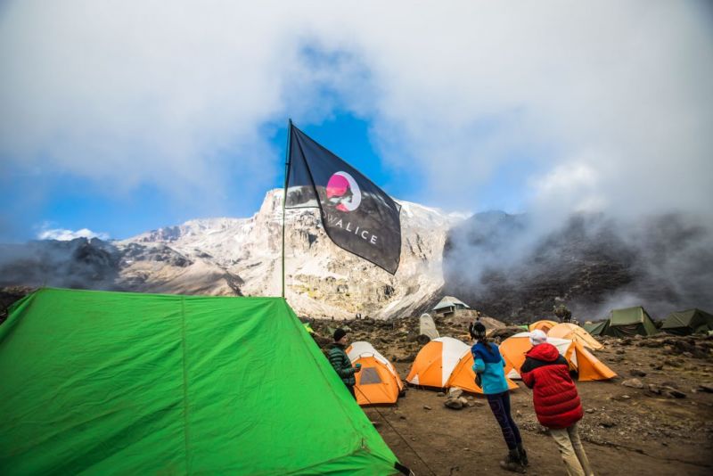 Trekkers wearing warm gear around camp on Kilimanjaro