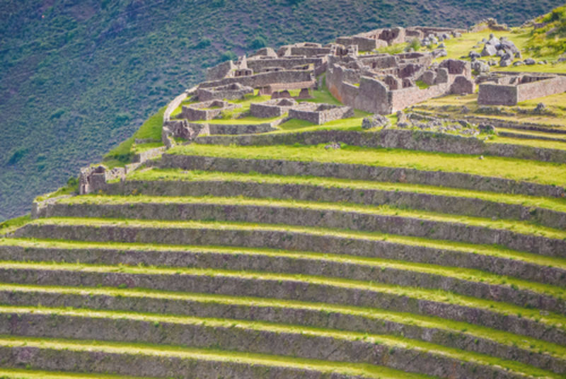 Ruins of inca town of Pisac in Peru on a green hill with farming terraces with shallow depth of field