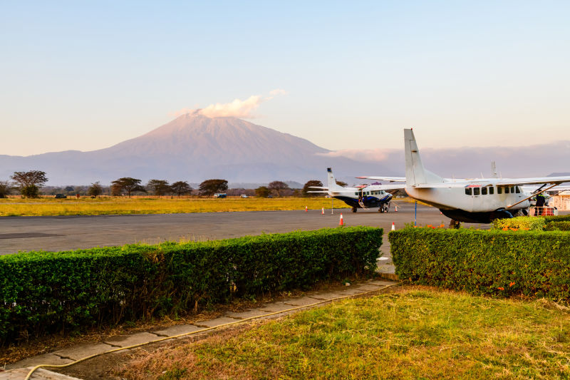 Mt Meru as seen from Arusha Airport with small aircraft and runway in foreground