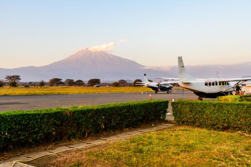 Mt Meru as seen from Arusha Airport with small aircraft and runway in foreground