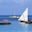 Old boats (dhow and other) and modern boat (catamaran) in Zanzibar on a sunny day