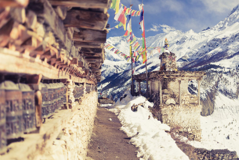Prayer wheels in high Himalaya Mountains, Nepal village. Focus on the stupa and prayers flags. Annapurna Two range region in Nepal, located at Annapurna Circuit Trekking Hiking Trail small