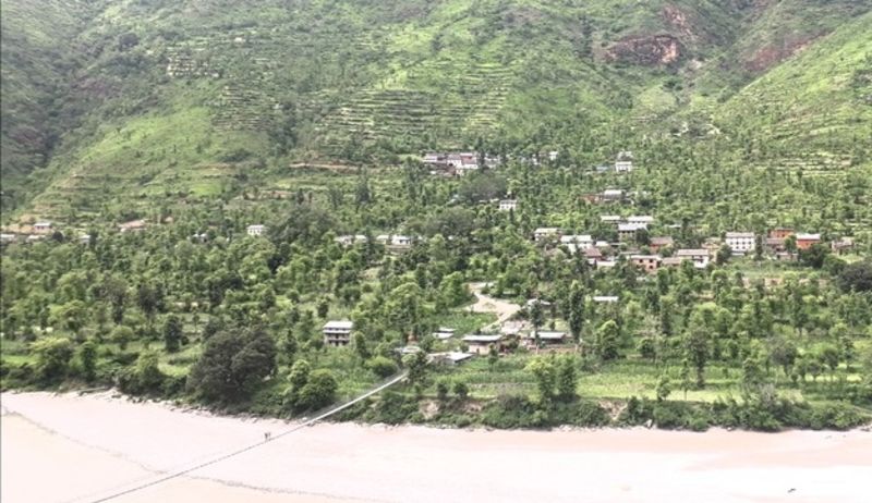 Unnamed village of Ramechhap District, tree-filled village on green hillside above middy river, Nepal