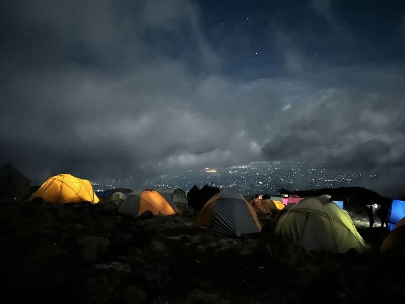 Kilimanjaro campsite at night with city lights below