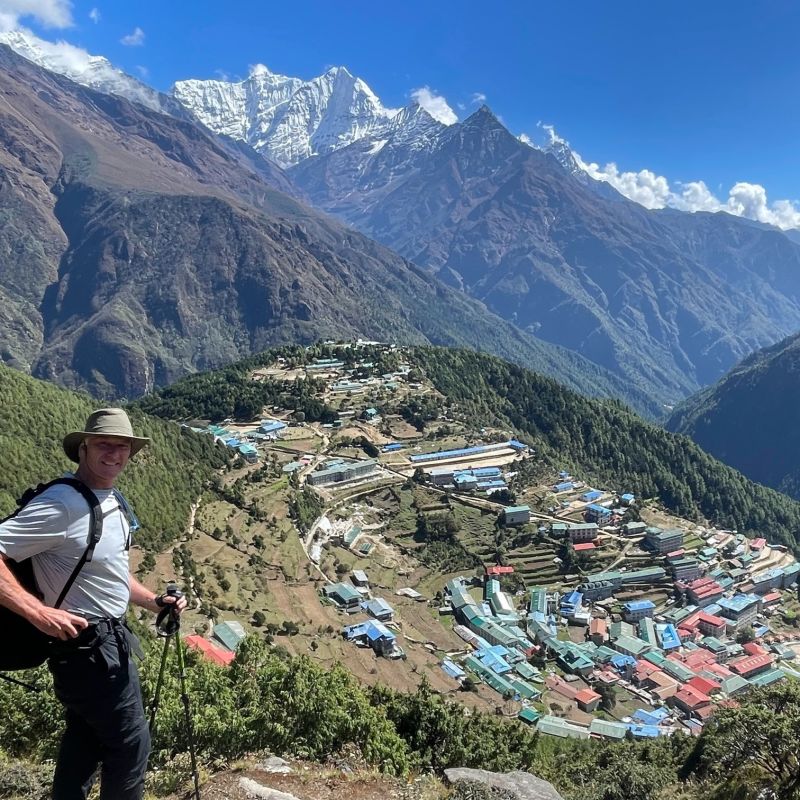 Trekker standing with Namche Bazaar in the background below on the EBC trek
