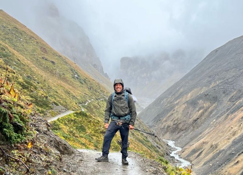 Male trekker on Annapurna Circuit trail in rain and mist