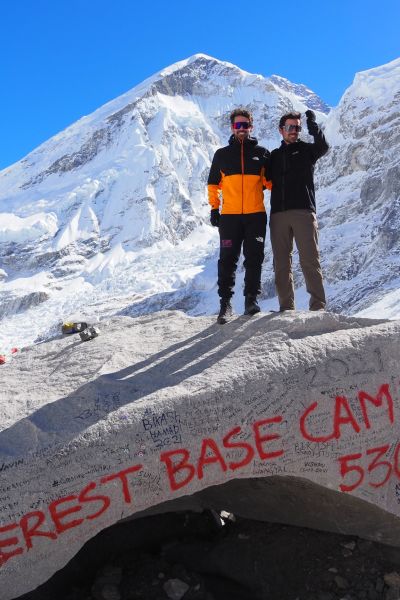 Trekkers standing atop rock at Everest Base Camp, EBC trek, Nepal 