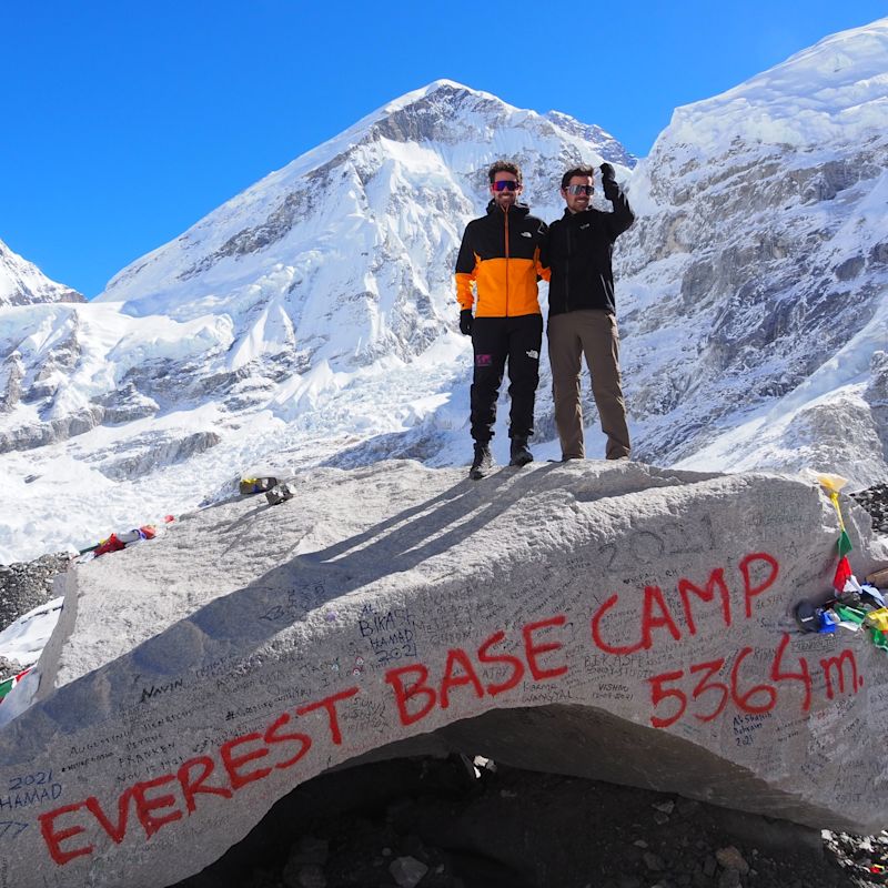 Trekkers standing atop rock at Everest Base Camp, EBC trek, Nepal 