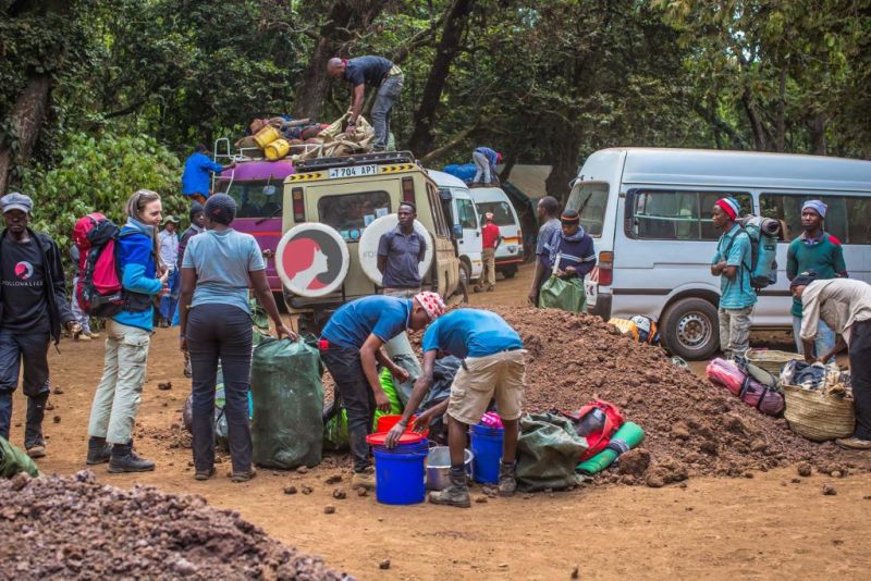 Vehicles and people as everyone prepares for a Kilimanjaro trek