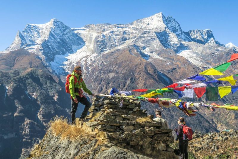 Trekkers by prayer flags and sontes