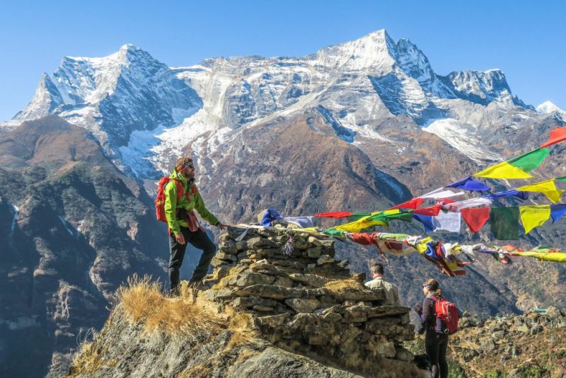 Trekkers by prayer flags and sontes