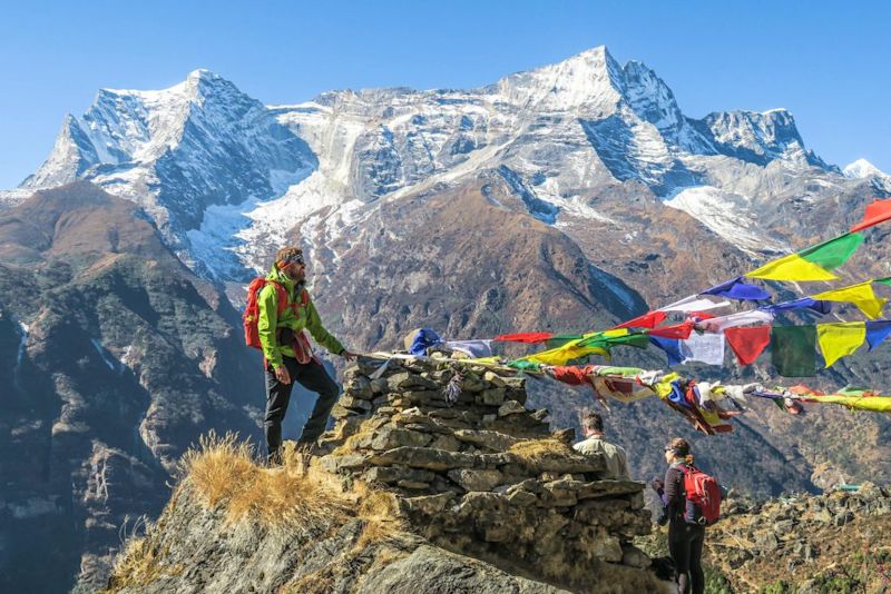 Trekkers by prayer flags and sontes