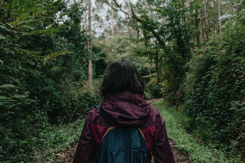 Woman with backpack walking in a forest